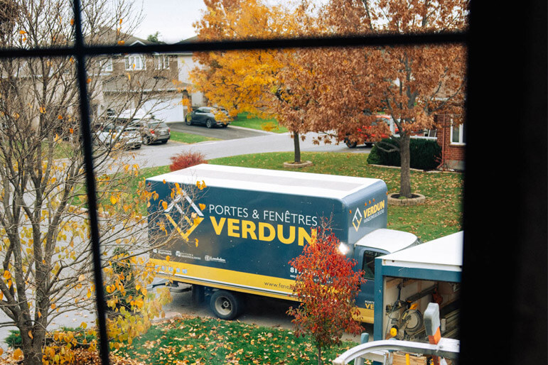 The view of a Verdun installation truck through a window from the interior of a home.