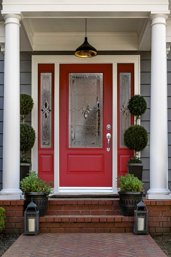 Une jolie porte d'entrée rouge avec des inserts en verre Niagara sur une dalle de porte Orléans.