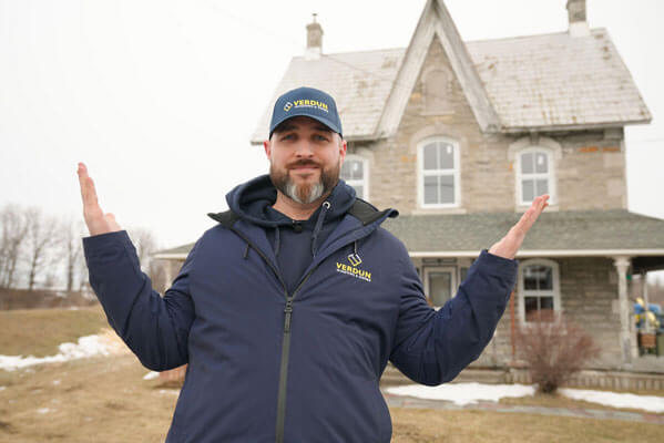 A Verdun sales rep stands in front of a newly renovated home with amazing new windows.