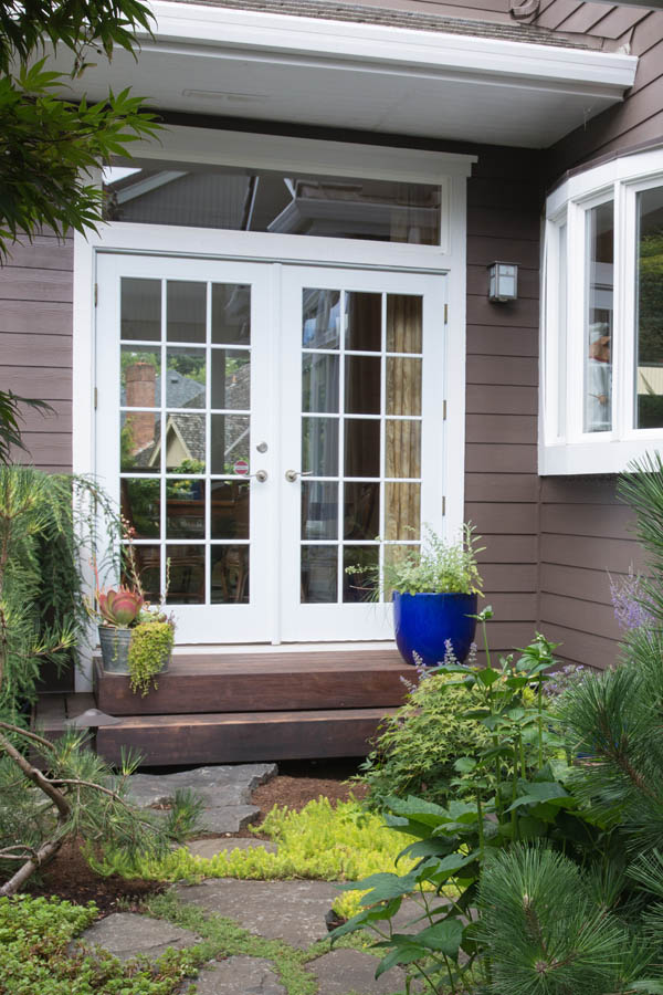 A white entry door with Georgian SDL glass inserts on a Flat door slab.