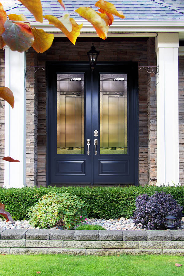 A dark blue entry door with Oak Hill glass inserts on an Orleans 95 door slab.