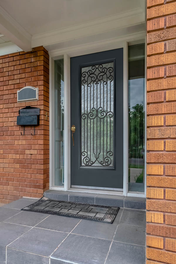 Une porte d'entrée avec inserts en verre Pinehurst sur une dalle de porte plate.