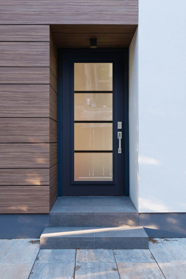 Une porte d'entrée avec inserts en verre pur sur une dalle de porte plate.