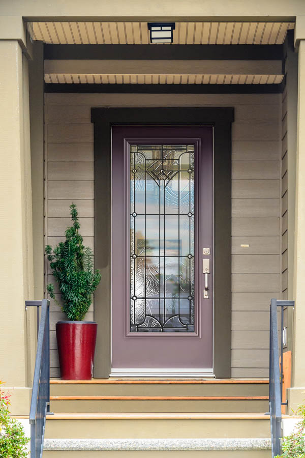 Une porte d'entrée gris violacé avec des inserts en verre Waterton sur une dalle de porte plate.