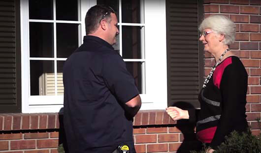 Window and door sales representative speaking with client after window installation